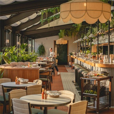 Waitress setting tables in bright and airy restaurant